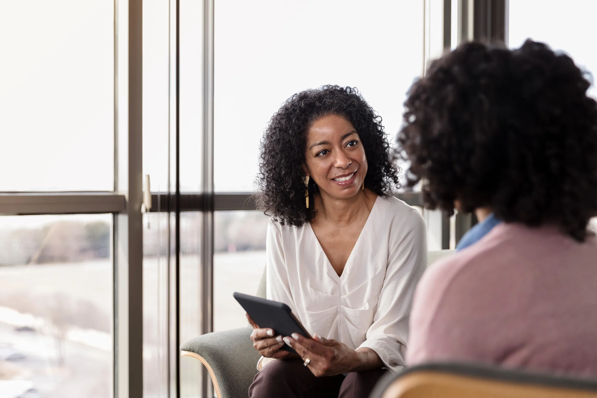 Two women in conversation during a gentle coaching-style session.
